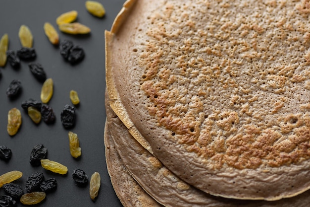 Een stapel havermout-bananenpannenkoekjes met plakjes verse bananen, walnoten en honing bovenop met kopje thee op een witte houten achtergrond Een gezond ontbijt Kopieer ruimte