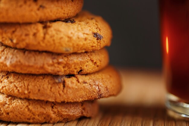 Een stapel havermoutkoekjes met chocoladeschilfers en een mok geurige zwarte hete thee