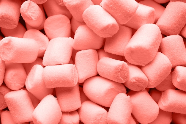 Een stapel kleine levende koraalkleurige gezwollen marshmallows.