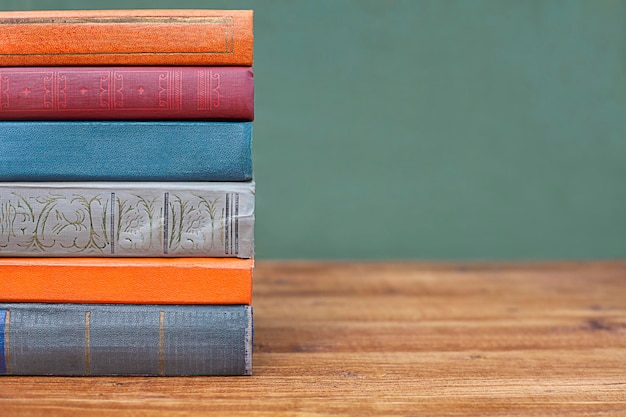 een stapel kleurrijke boeken op een tafel close-up op een groene achtergrond