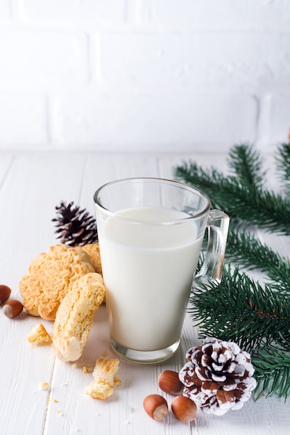 Een stapel koekjes en een glas melk voor Kerstman op houten achtergrond