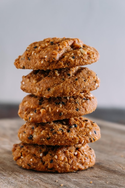 Een stapel koekjes met de bovenste op een houten ondergrond.