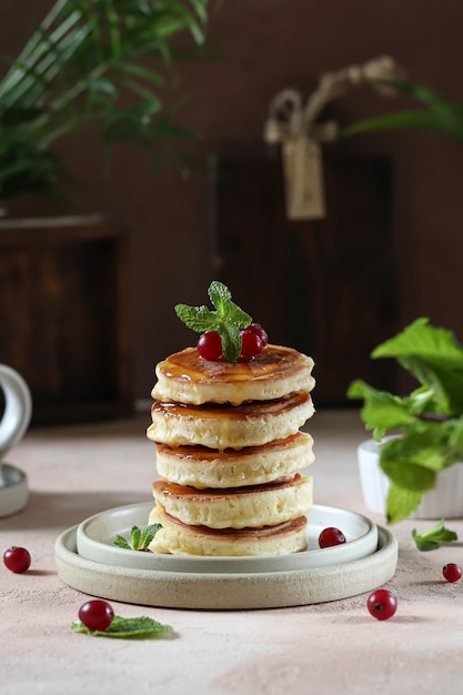 Een stapel pannenkoeken met daarop een cranberry