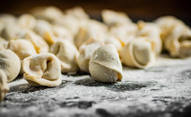 Een stapel rauwe ravioli op een met bloem bestoven oppervlak