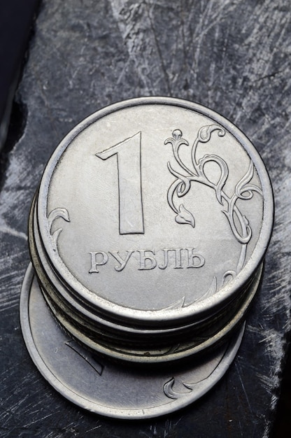 Een stapel Russische roebels ligt op een bekrast metalen oppervlak vertaling van de tekst op de munt quot1 roebelquot
