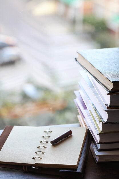 Een stapel schoolboeken op de vensterbank en schrijfgerei