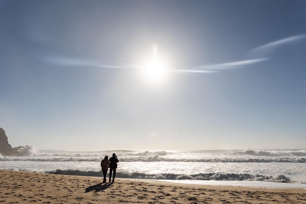 Een stel dat op het strand staat en naar de zee kijkt