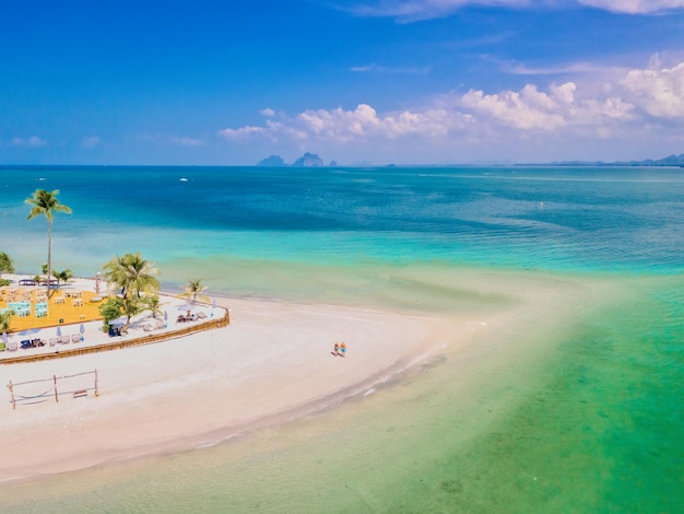 een stel mannen en vrouwen lopen op het strand tijdens een tropische vakantie in Thailand