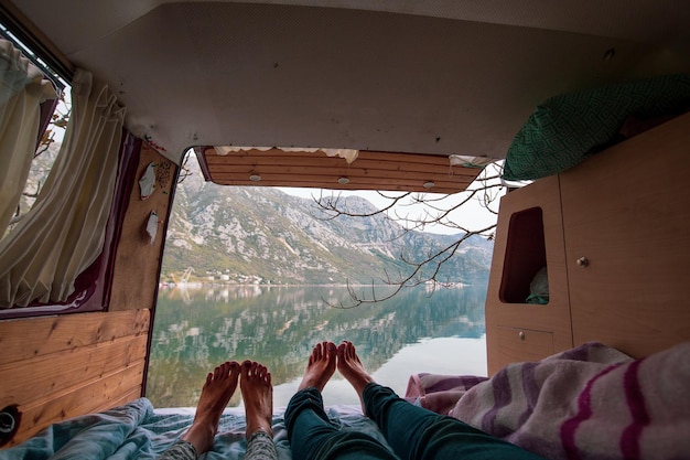 Een stel relaxt in hun camper, met de bergen op de achtergrond.