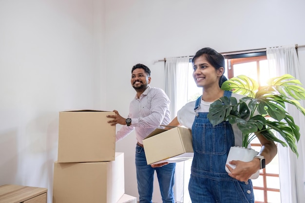 Een stel verhuist vrolijk naar een nieuw huis, houdt dozen vast en verplaatst dingen samen