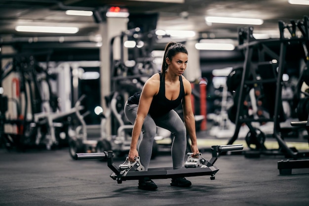 Een sterke vrouwelijke bodybuilder is gewichtheffen in een sportschool