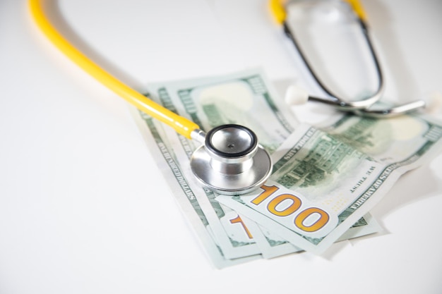 Een stethoscoop en geld op een witte achtergrond - concept van gezondheidszorgkosten