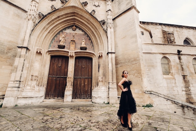 Een stijlvolle bruid in een zwarte trouwjurk poseert in de oude Franse stad Avignon