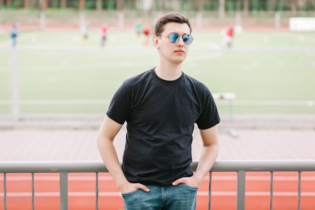 Een stijlvolle man in een zwart T-shirt. Straatfoto