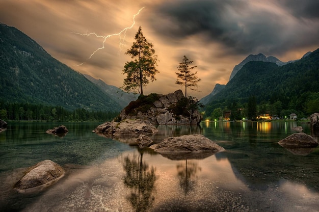 Een storm raakt de bergen en het meer wordt verlicht door bliksem.