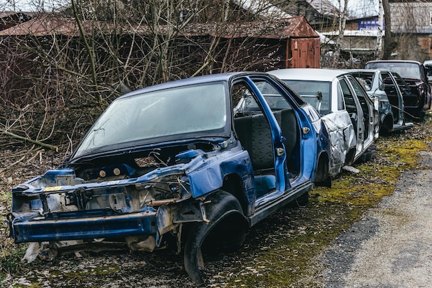 Een stortplaats met kapotte, verroeste auto's, hun onderdelen en banden