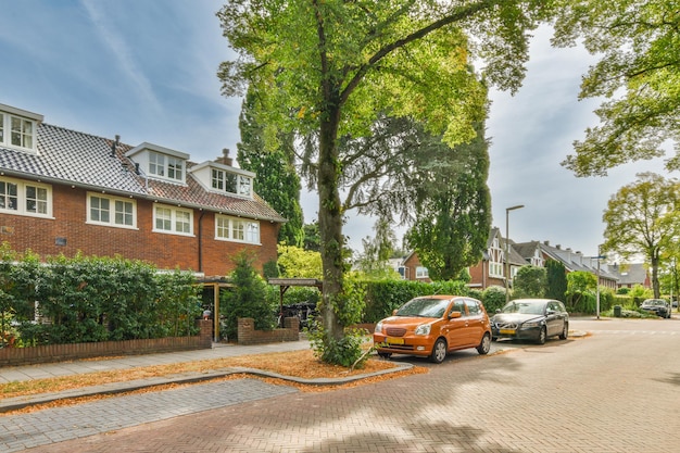 Een straat met geparkeerde auto's voor een huis