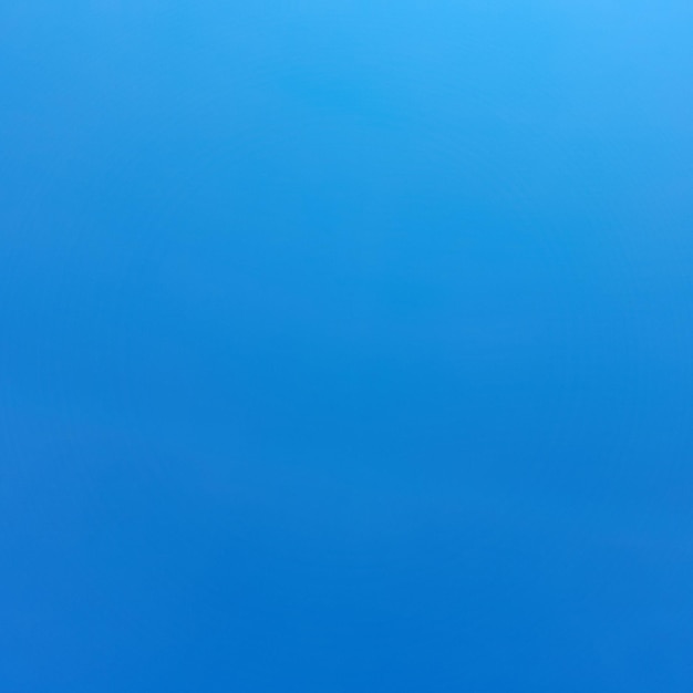 Een strakblauwe lucht met een witte wolk in het midden.