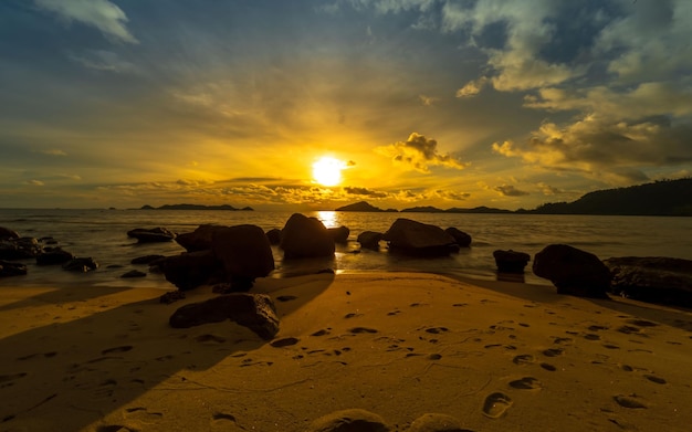 Een strand bij zonsondergang met een zonsondergang op de achtergrond