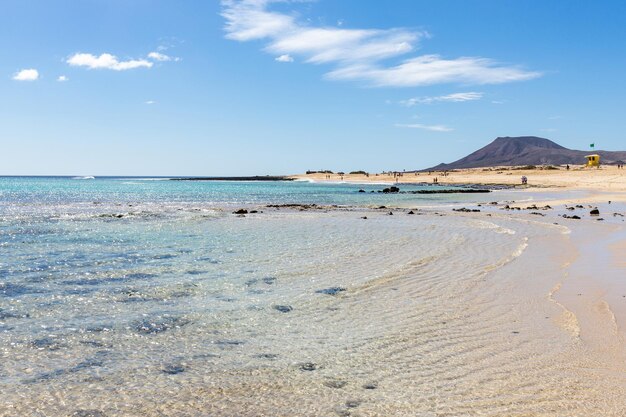 Een strand met een berg op de achtergrond