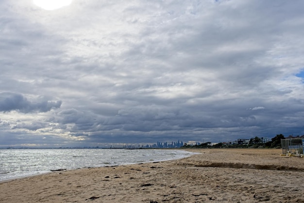 Een strand met een bewolkte lucht en een man op een boot op het strand