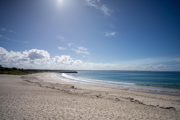 Een strand met een blauwe lucht en de zon erop