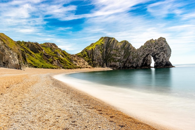 Een strand met in de verte een waterval