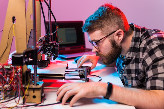 Een student man print prototype op printer.