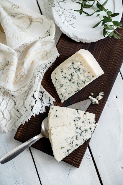 Een stuk dor blauwe kaas op een kaasplankje met messen delicatesse blauwe kaas.