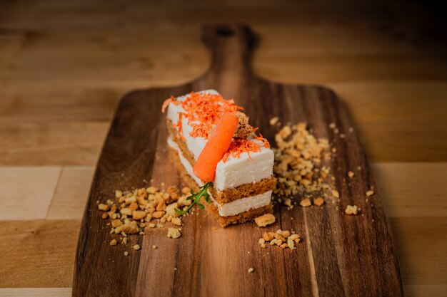 Een stuk van carrot cake op een houten bord