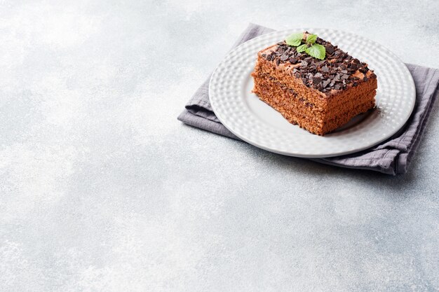 Een stuk van truffelcake met chocolade op een grijze concrete achtergrond. Ruimte kopiëren