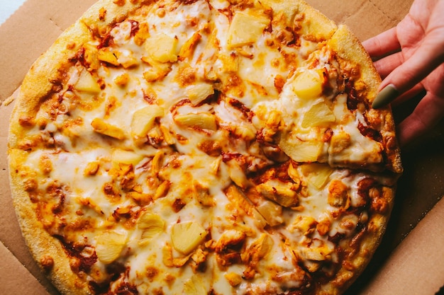 een stuk zeer smakelijke pizza met plakjes ananas en kaas close-up vintage fotoverwerking