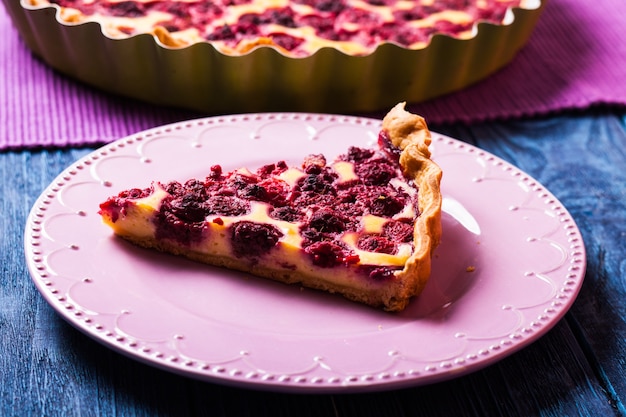 Een stukje cheesecake met frambozen op een bord