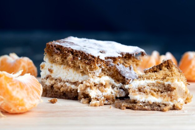 Een stukje honingcake met vanillecrème en citrusmandarijnen