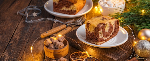 Een taart op een kerstachtergrond met een brandende slinger Prettige kerstdagen en gelukkig nieuwjaar