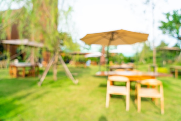 Een tafel en stoelen in een tuin met een parasol op tafel.