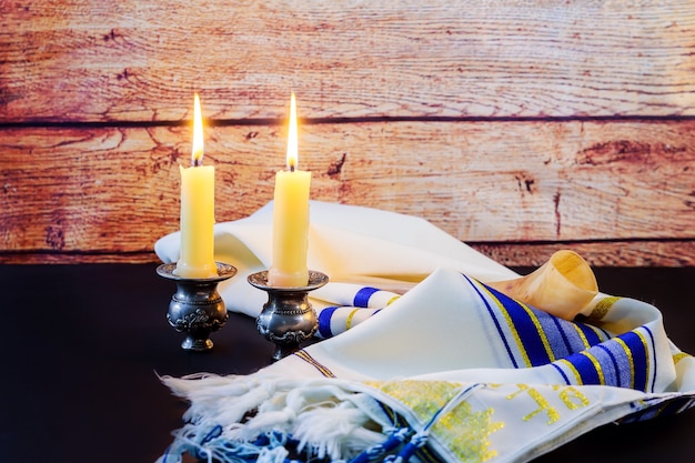 Een tafel gedekt voor Shabbat met brandende kaarsen, challah brood en wijn.