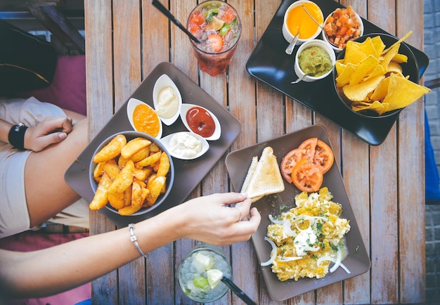 Een tafel met borden met eten, waaronder een sandwich, salsa, guacamole en salsa.