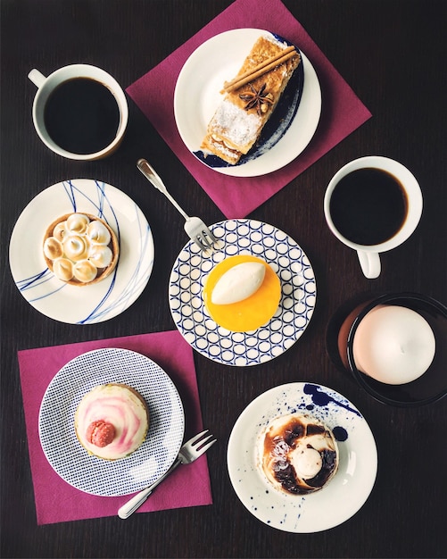 Een tafel met borden met eten waaronder een taart een kopje koffie en een bord eten