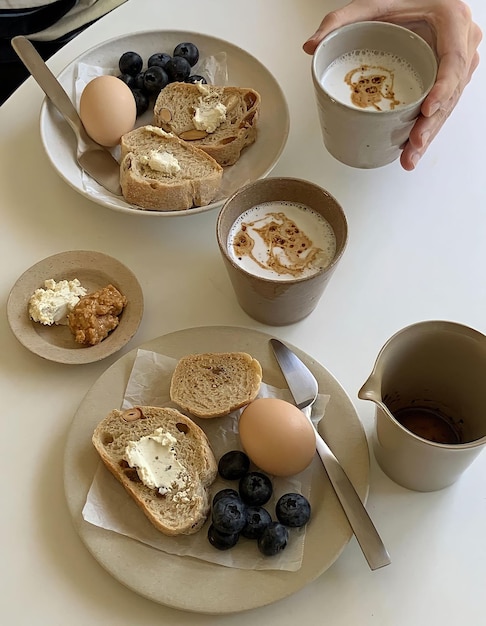 Foto een tafel met borden met eten, waaronder eieren, koffie en een kopje koffie.