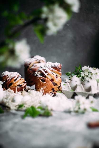 Een tafel met drie muffins met een witte crème en een takje munt.