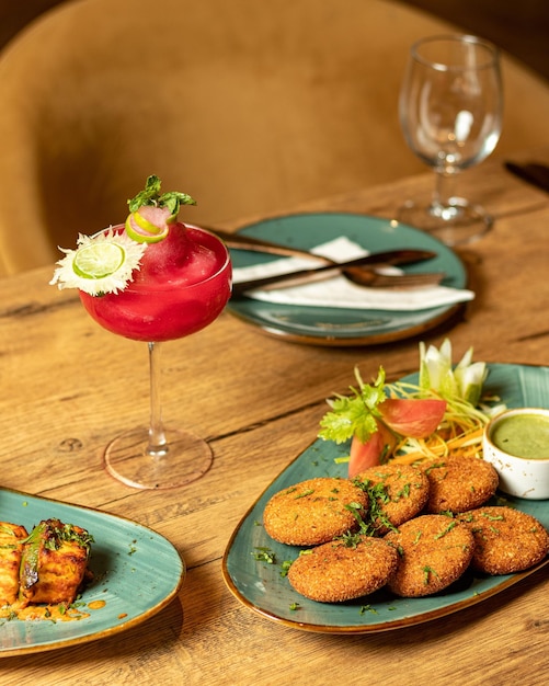 Een tafel met een bord eten en een glas cocktail