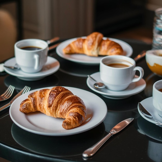een tafel met een croissant en koffie erop