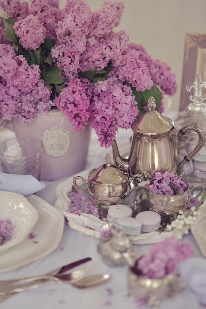 Een tafel met een paars bloemstuk