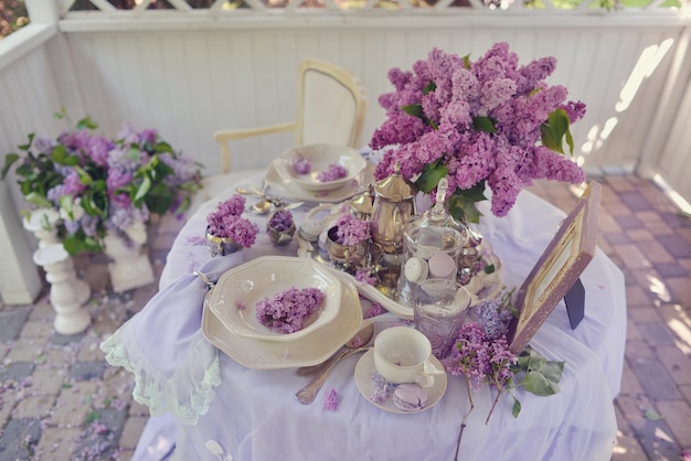 Een tafel met een paars tafelkleed en paars lila bloemen.