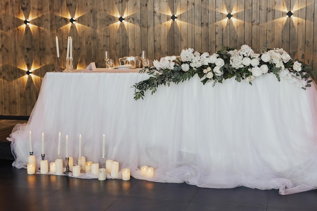 Een tafel met een wit tafelkleed en witte bloemen