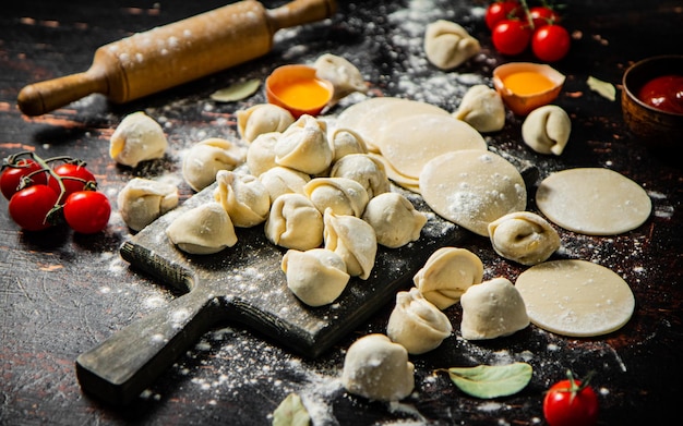 Een tafel vol eten, waaronder knoedels, tomaten en andere ingrediënten