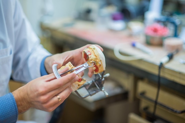 Een tandtechnicus maakt gedeeltelijk kunstgebit De productie van valse tanden of tandbruggen Close-up