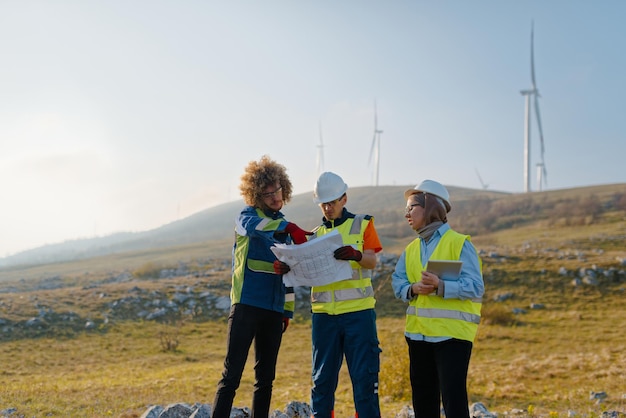 Foto een team ingenieurs en arbeiders houdt toezicht op een windturbineproject op een modern windpark