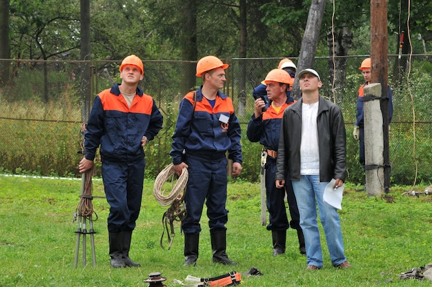 Een team van elektriciens bereidt zich voor om de hoogspanningslijn te repareren